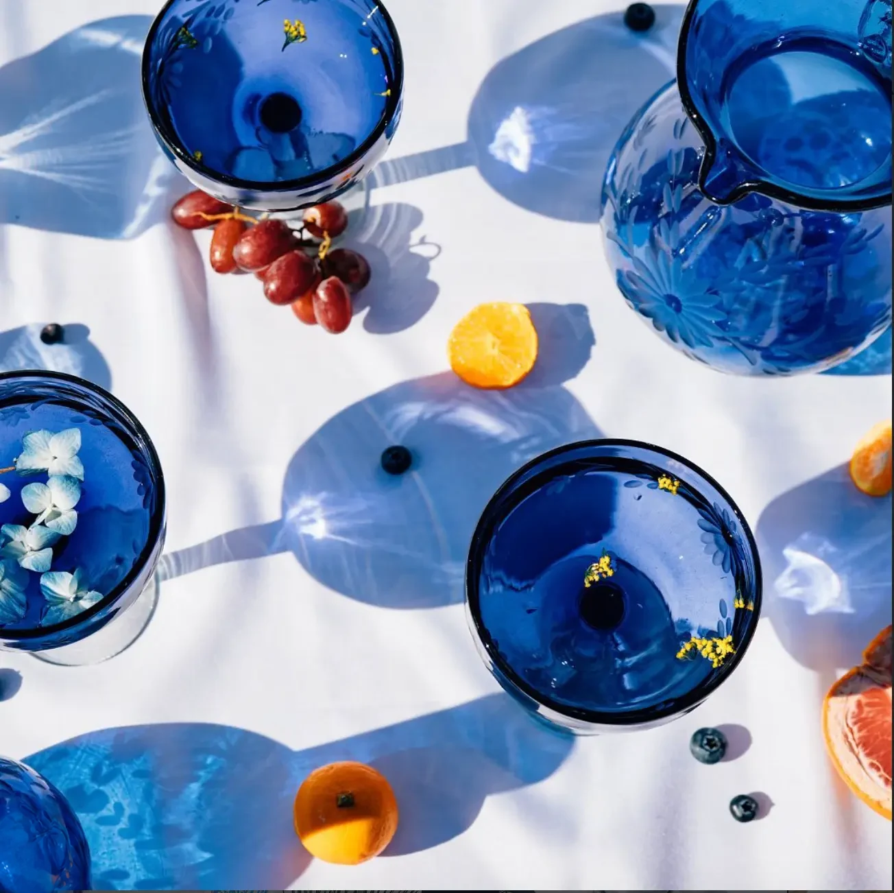 Cobalt handblown glasses arranged with fruit and flowers