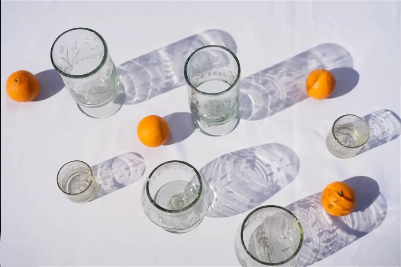 Hand-etched glasses and citrus casting geometric shadows